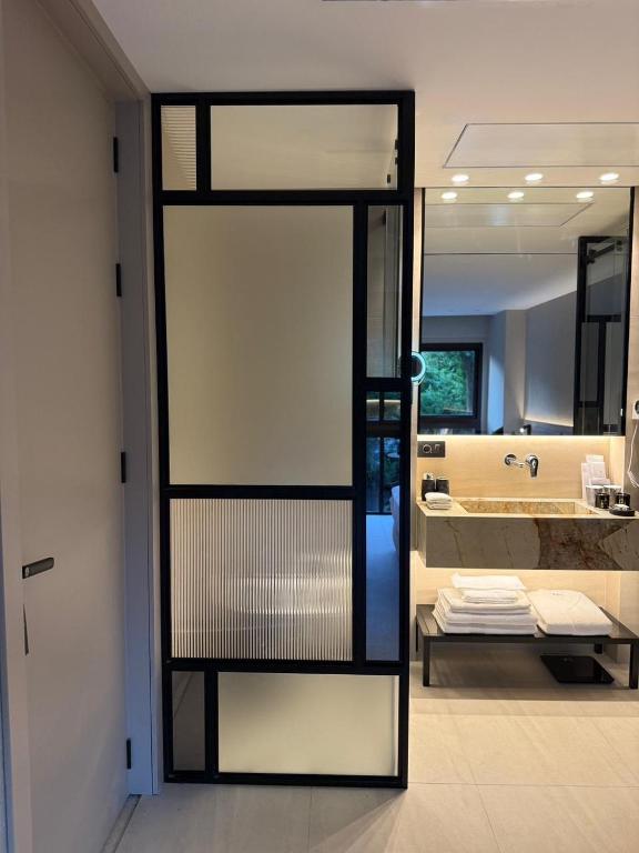 a bathroom with a glass door leading to a tub at Local Sursock in Beirut