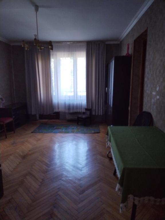 a living room with a green table and a window at Lalo in Tbilisi City