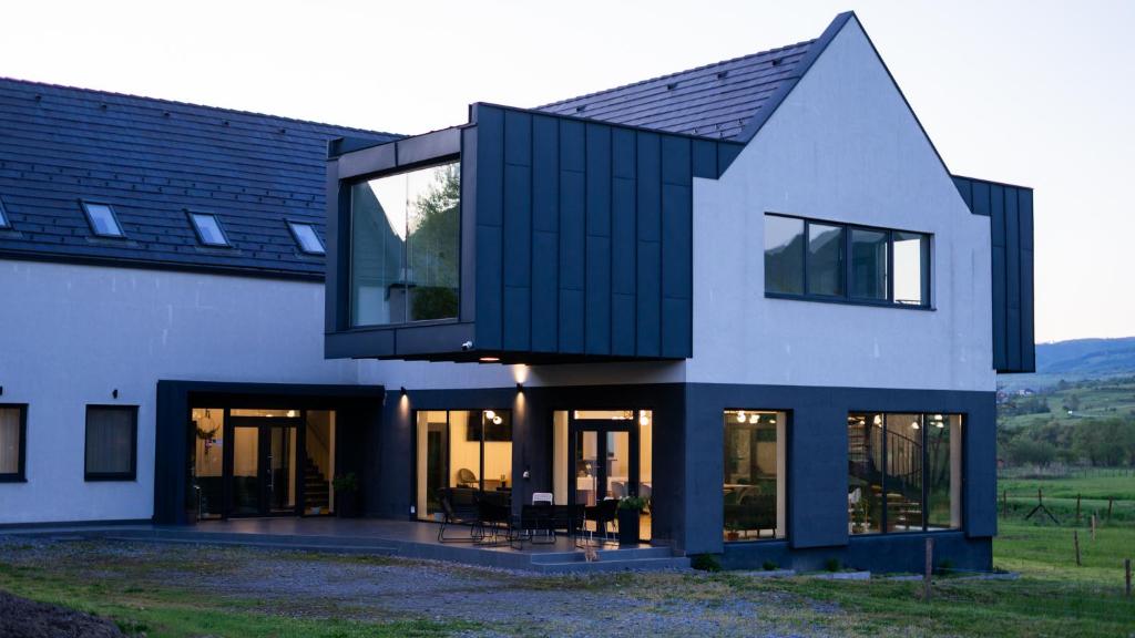 a house with black and white at Pensiunea Qubik Praid in Ocna de Jos