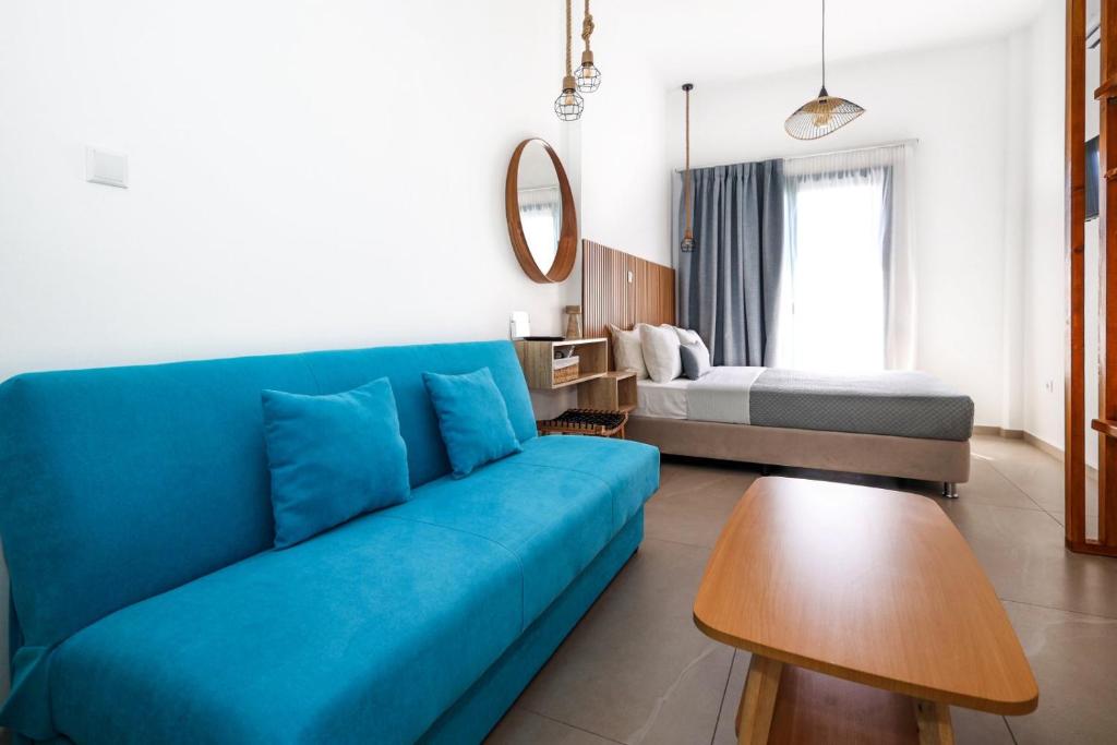 a living room with a blue couch and a bed at Galaxias Studios in Skala