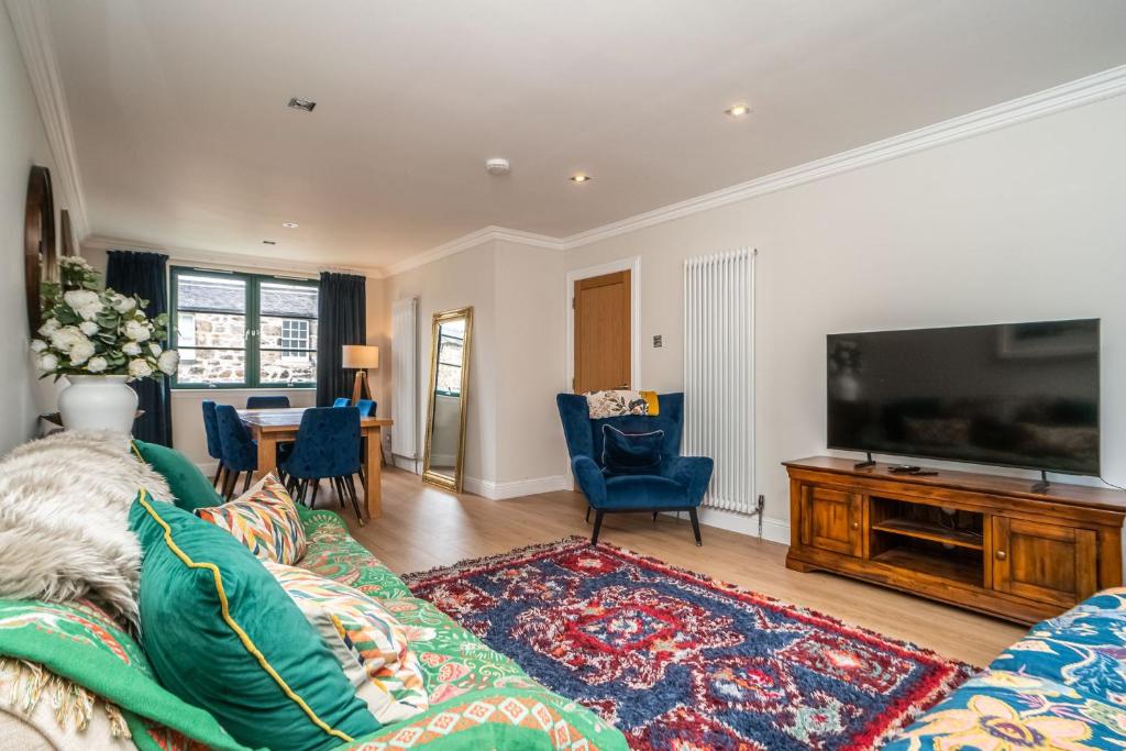 a living room with a couch and a flat screen tv at A beautiful mews house in a city centre in Edinburgh