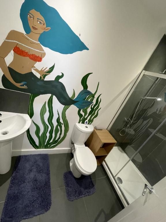 a bathroom with a mermaid mural on the wall at 1 Marine House in Penzance