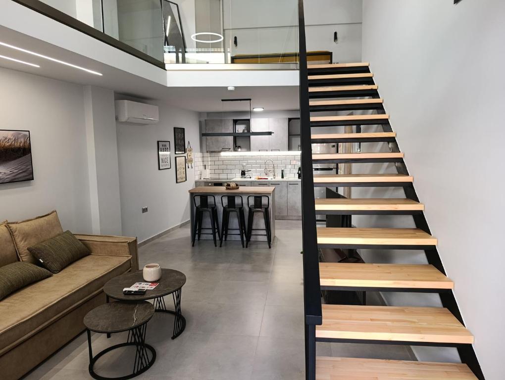 a staircase in a living room with a couch and a table at Alkaiou Loft in Kalamata