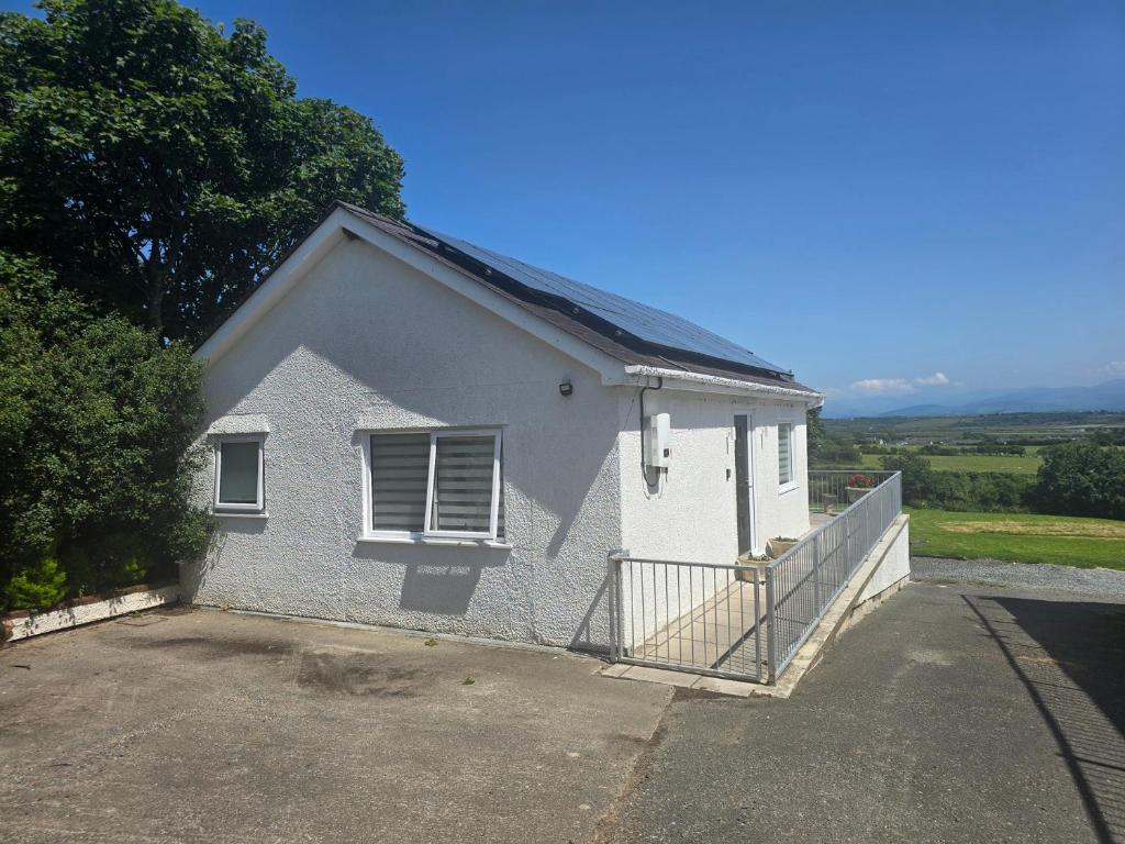 a small white house with a driveway at Ty Nain in Bodorgan