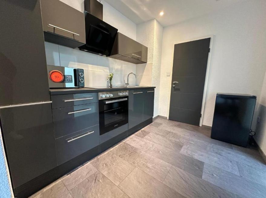 a kitchen with a black stove top oven in a room at Beautiful Apartment in Mönchengladbach mit Wintergarten in Mönchengladbach