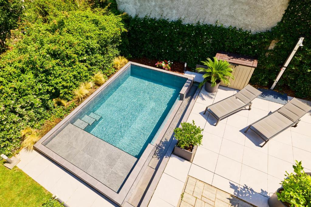 an overhead view of a swimming pool with two lawn chairs at Villa Gio's in Monza