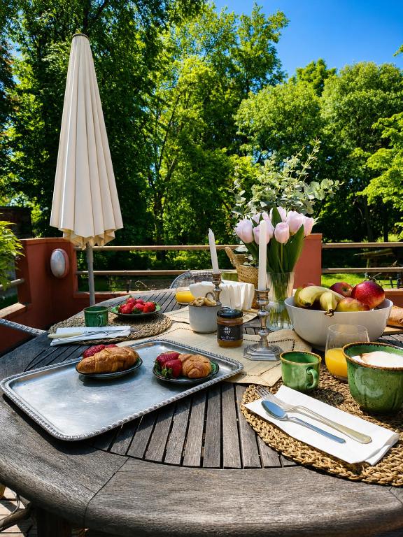 a picnic table with food on it with an umbrella at Garden Loft by Veneto Villa in Albignasego