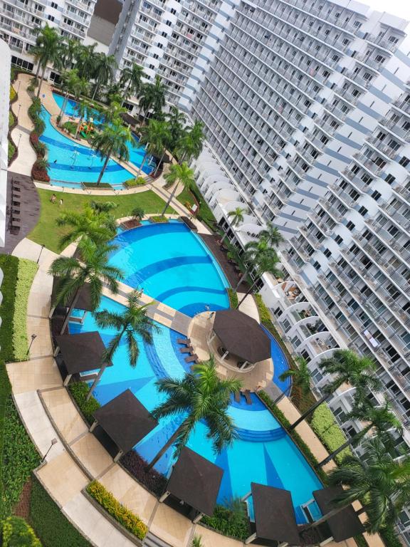 an overhead view of a hotel pool with a large building at Shell Residences MOA&NAIA by-Sandy in Manila