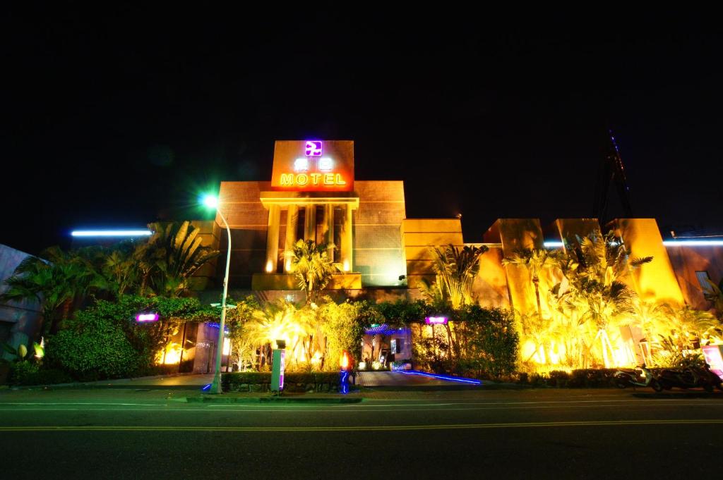 budynek z neonem na nim w nocy w obiekcie Holiday Motel w mieście Tainan