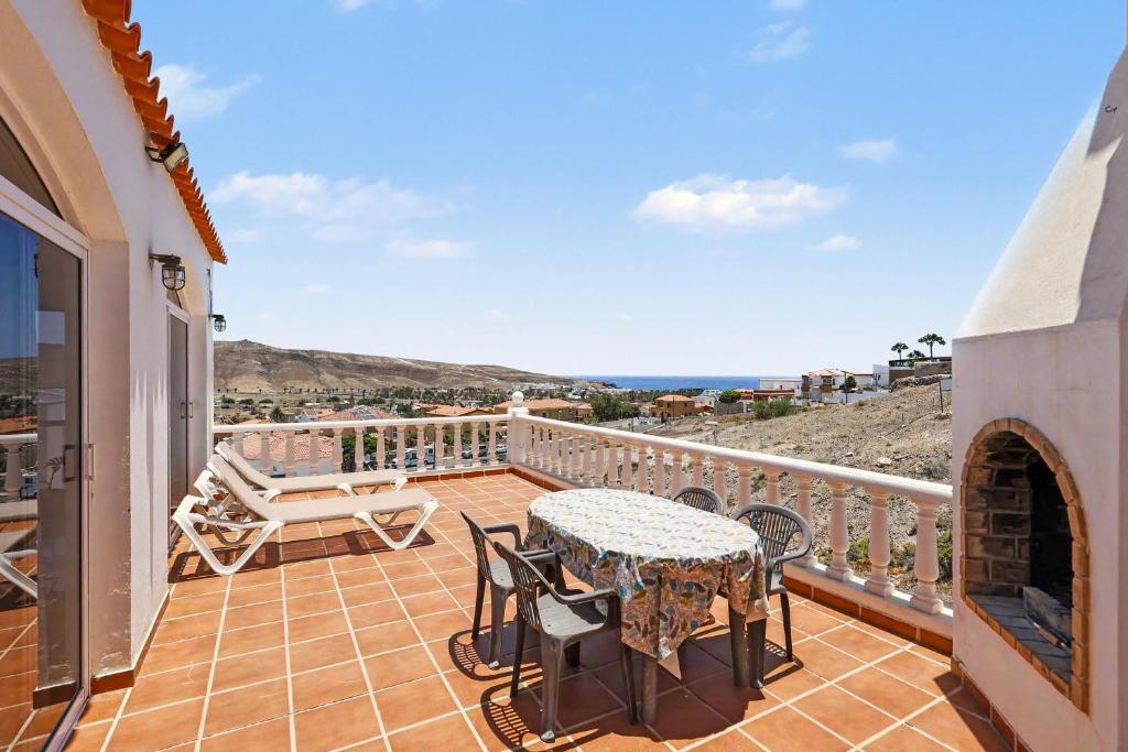 a patio with a table and chairs on a balcony at Villa Gabriela in Tarajalejo