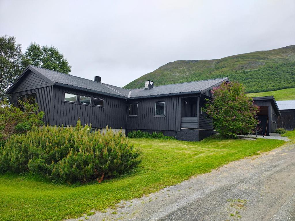 a black house on the side of a road at Three bedroom home with an amazing mountain view! in Oppdal
