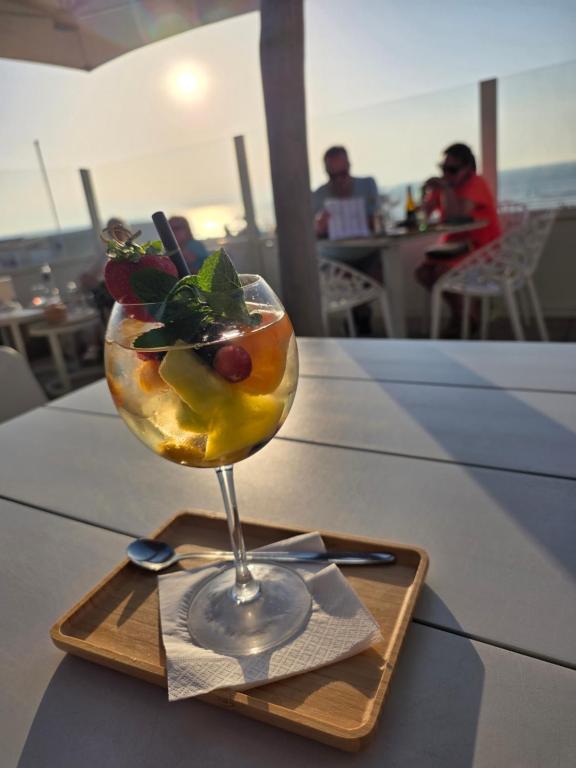 a martini glass with fruit on a plate on a table at Duinenbank in Bredene