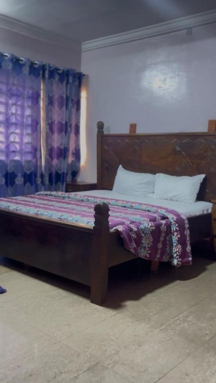 a bedroom with a bed with a purple comforter at Diamond Hotel Lagos in Lagos