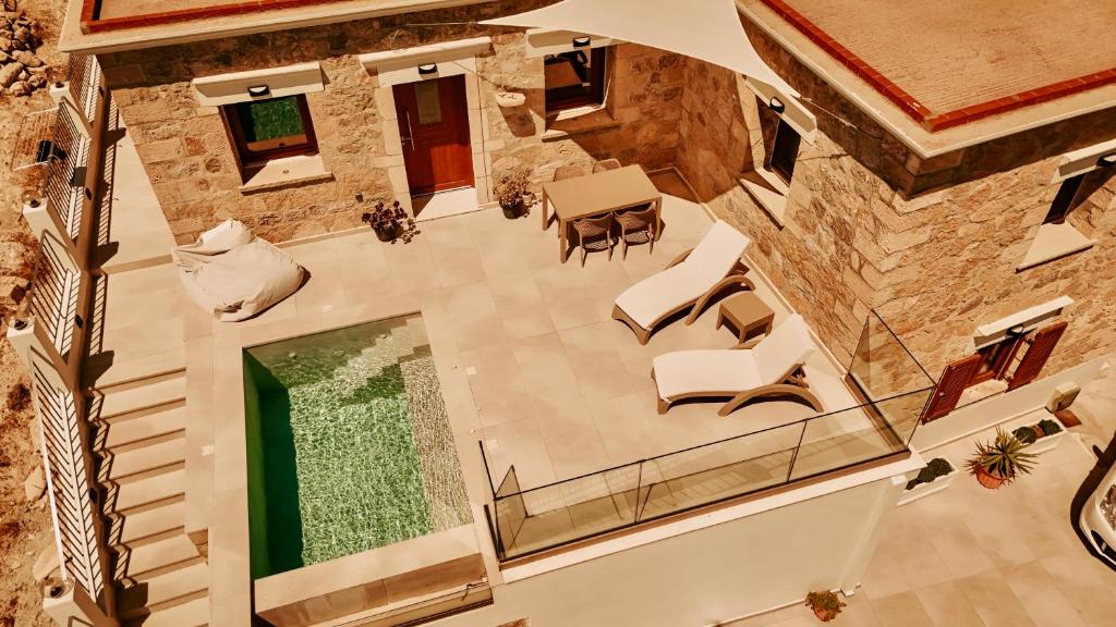 an overhead view of a living room with a stone building at Lithos Luxury Pool Villa in Karpathos