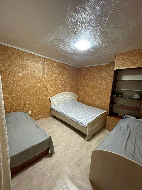 a room with two beds in a room with a wall at Дом in Borovoye