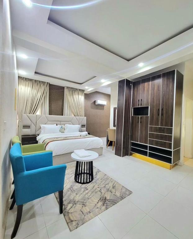 a hotel room with a bed and a blue chair at 2 bedroom Atrium apartment in Gwarinpa
