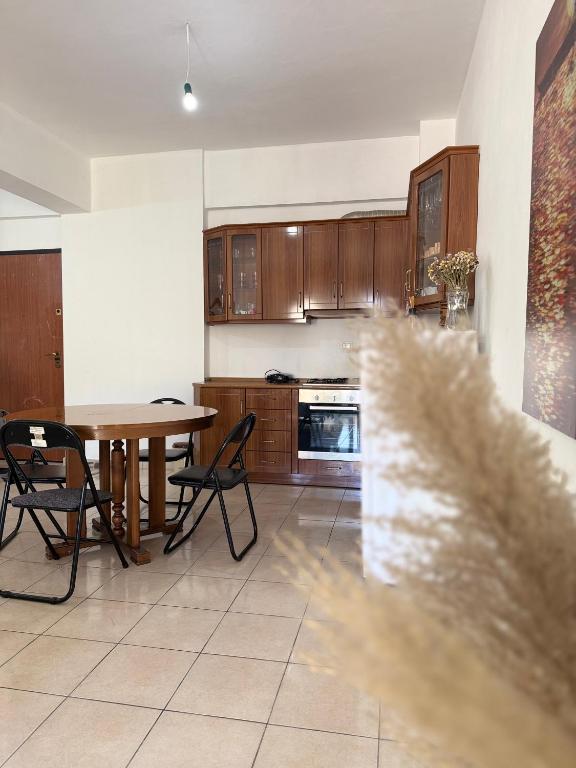 a kitchen with wooden cabinets and a table and chairs at AS Orikum 1 in Orikum