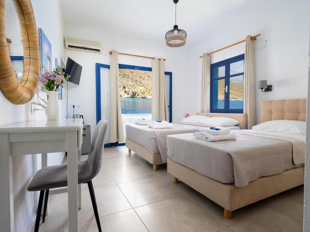 a bedroom with two beds and a table and chairs at Sifis in Loutro