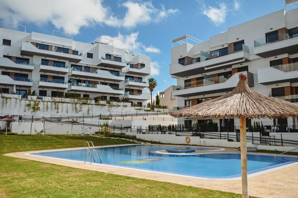 a large apartment building with a swimming pool and an umbrella at Xava Dreams Aire in Villacosta