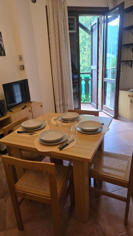 a wooden table with plates and glasses on it at Il rifugio della Presolana in Castione della Presolana