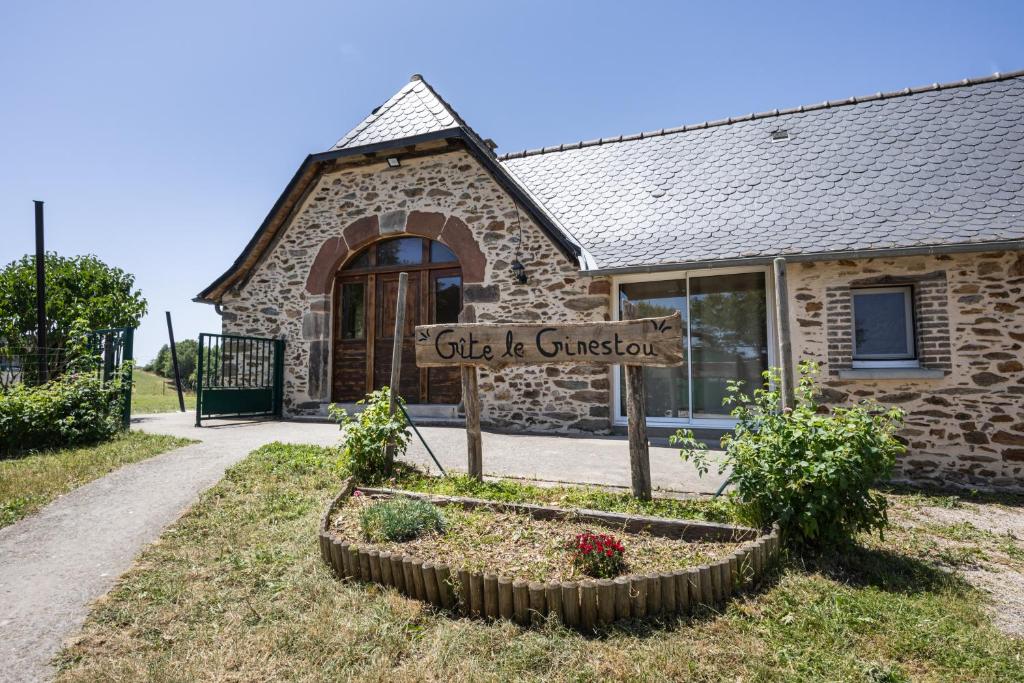 a sign in front of a stone building at Gite Le Ginestou in Almon-les-Junies