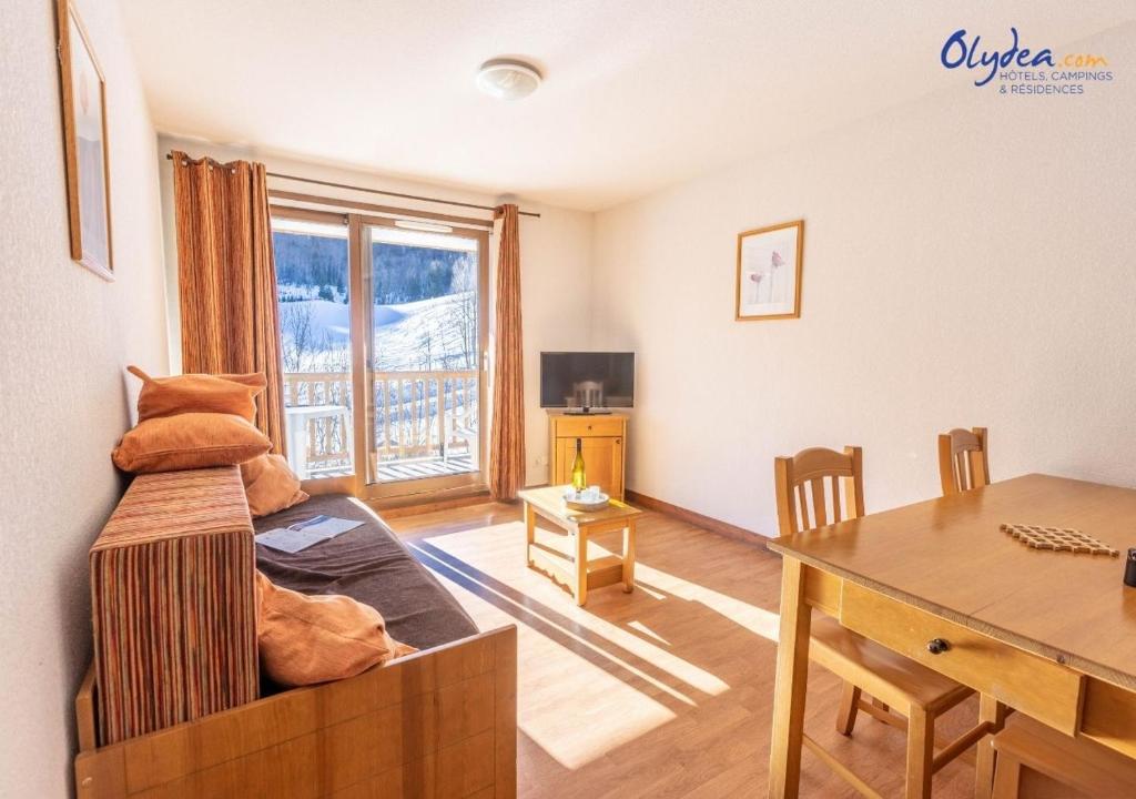 a living room with a desk and a table with a dining room at Olydea les Bottieres - Saint-Pancrace in Saint-Pancrace