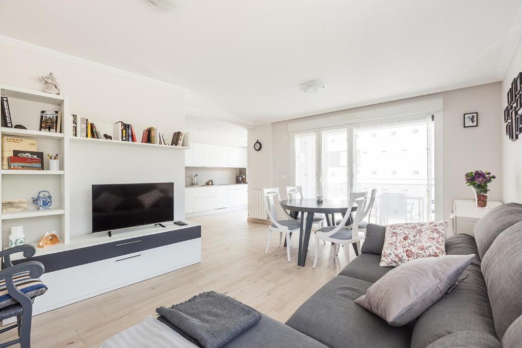 a living room with a couch and a tv and a table at Ardantza Bidea - baskeyrentals in Zumaia