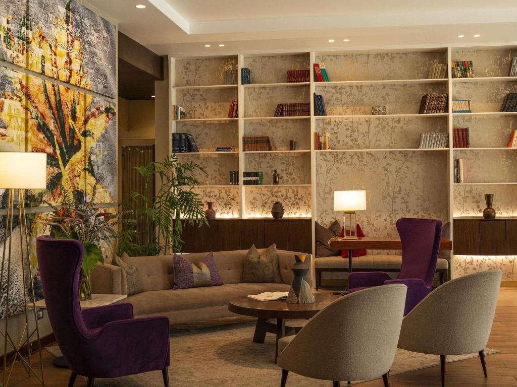 a living room with a couch and a table and chairs at Manto Hotel Lima - MGallery Collection in Lima