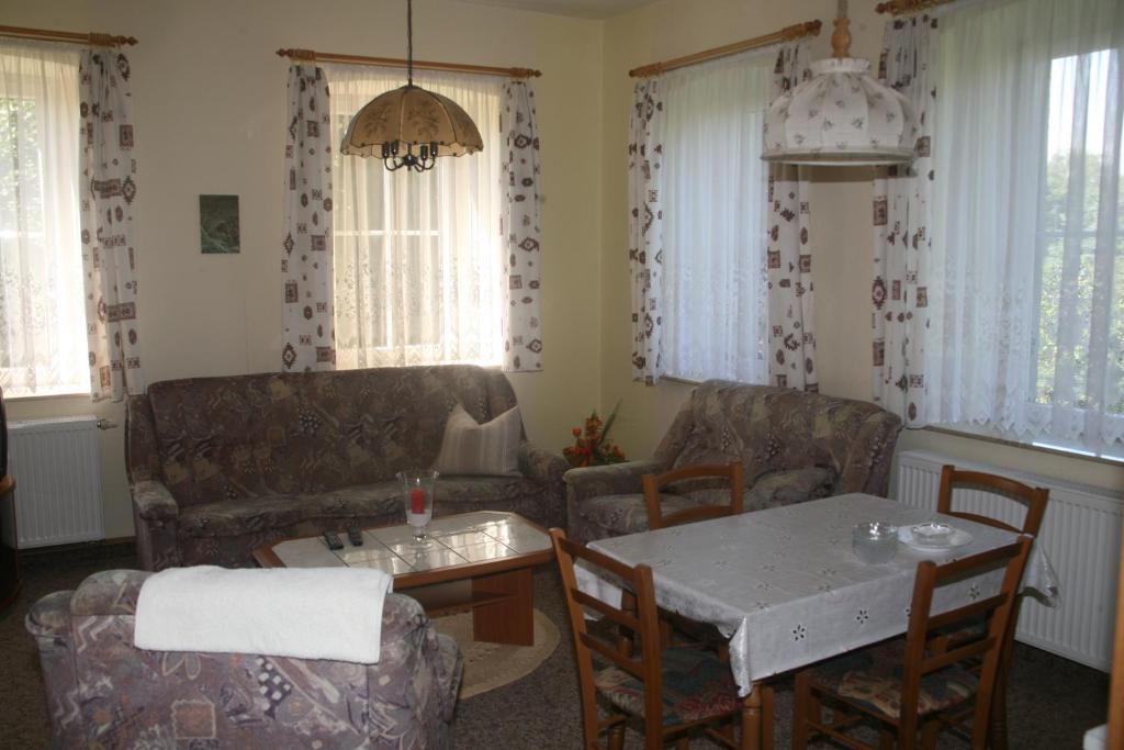 a living room with a couch and a table and chairs at Pension Böhmer in Stolpen