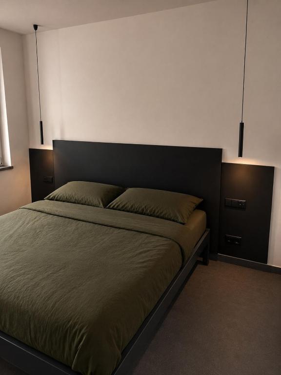 a bedroom with a bed with two lights above it at Stilvolles Premium Apartment in Haßfurt