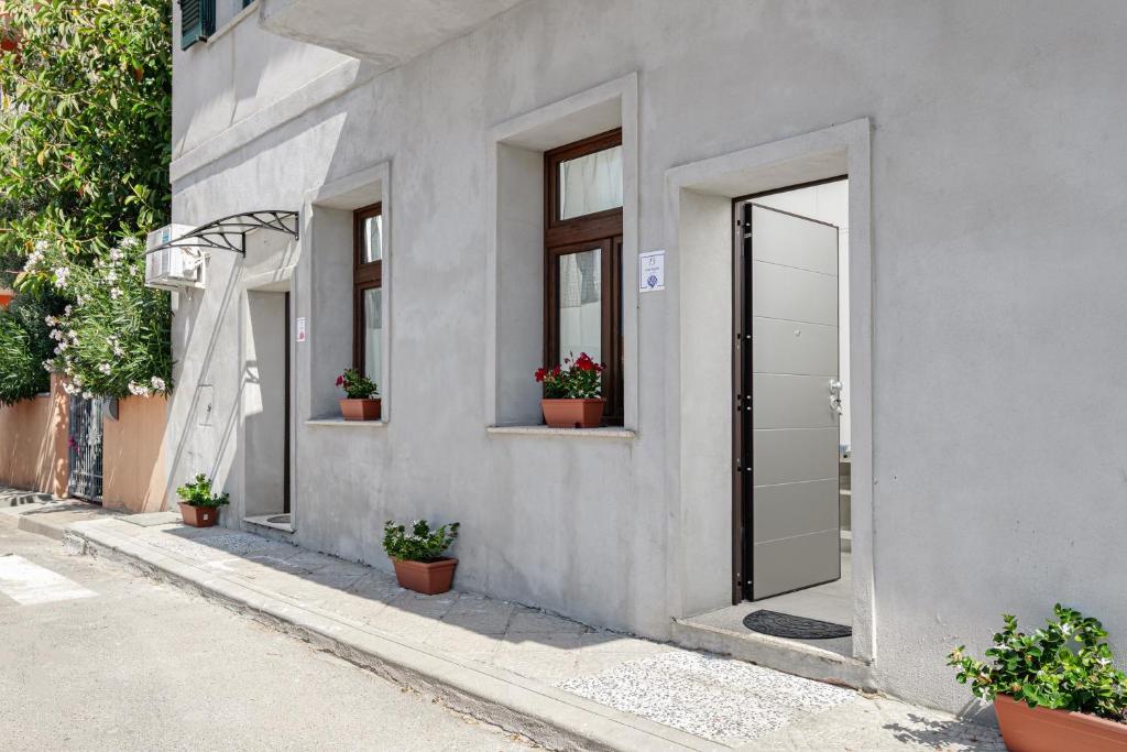 a gray building with a door and potted plants at Appartamenti Corallo e Conchiglia in Olbia