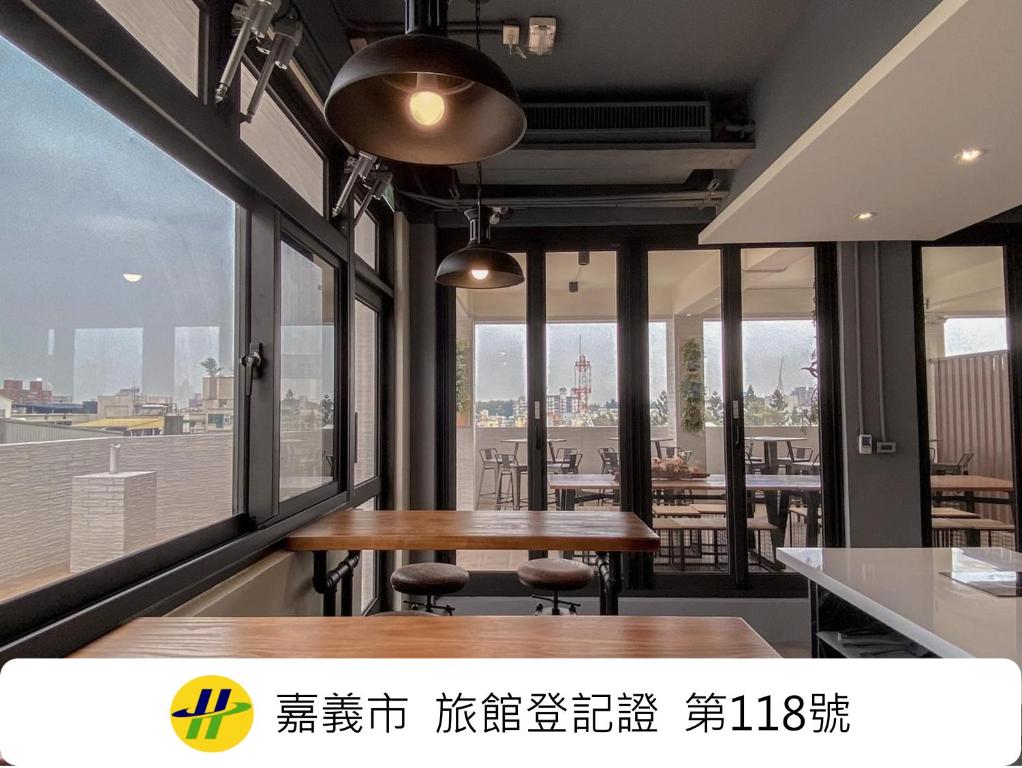 a dining room with a table and some windows at Island Hearth Chiayi in Chiayi City
