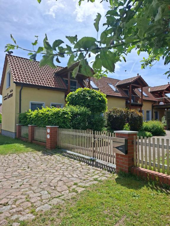 a wooden fence in front of a house at Design Ferienhaus Kamerun an der Elbe in Damnatz