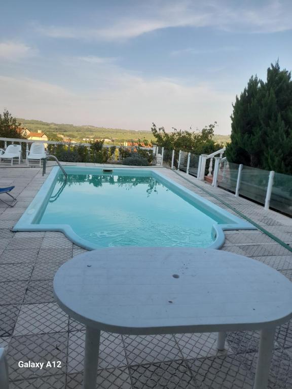 a swimming pool with a table in front of it at cupido feeling nomad in Souro Pires