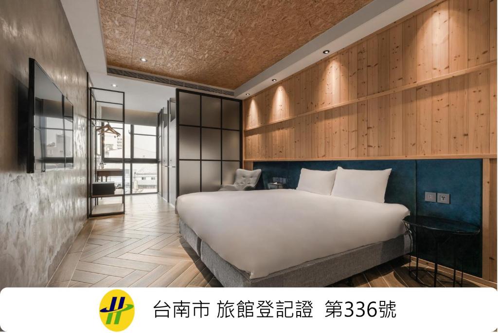 a bedroom with a large white bed and wooden walls at Island Heart Tainan Hotel in Tainan