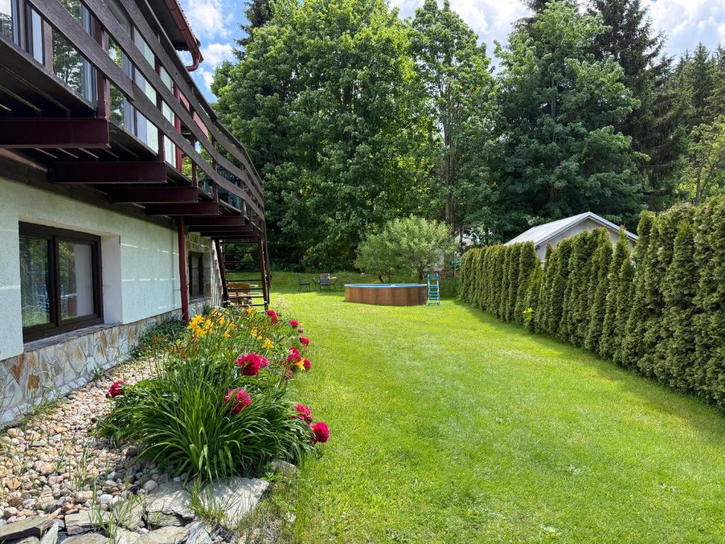 a yard with flowers next to a building at Chalupa 387 in Harrachov