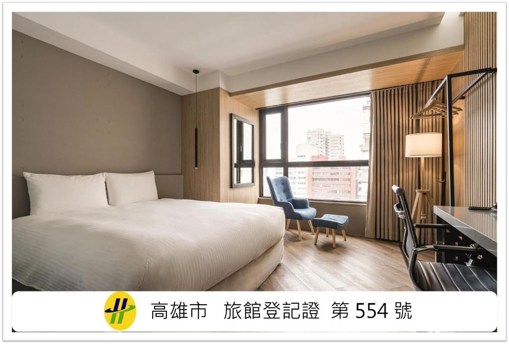 a hotel room with a bed and a desk and a window at Island Heart Kaohsiung Hotel in Kaohsiung