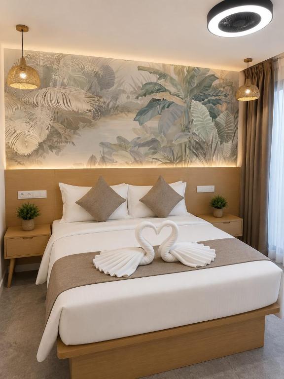 a bedroom with a large bed with two white towels at Veli Beach Inn in Mathiveri
