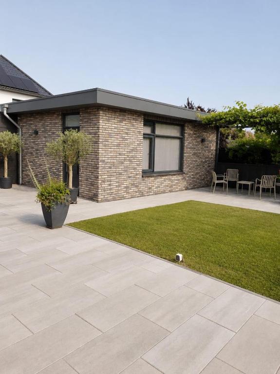 a patio with a grass yard and a house at Plekkenpolhof in Enschede