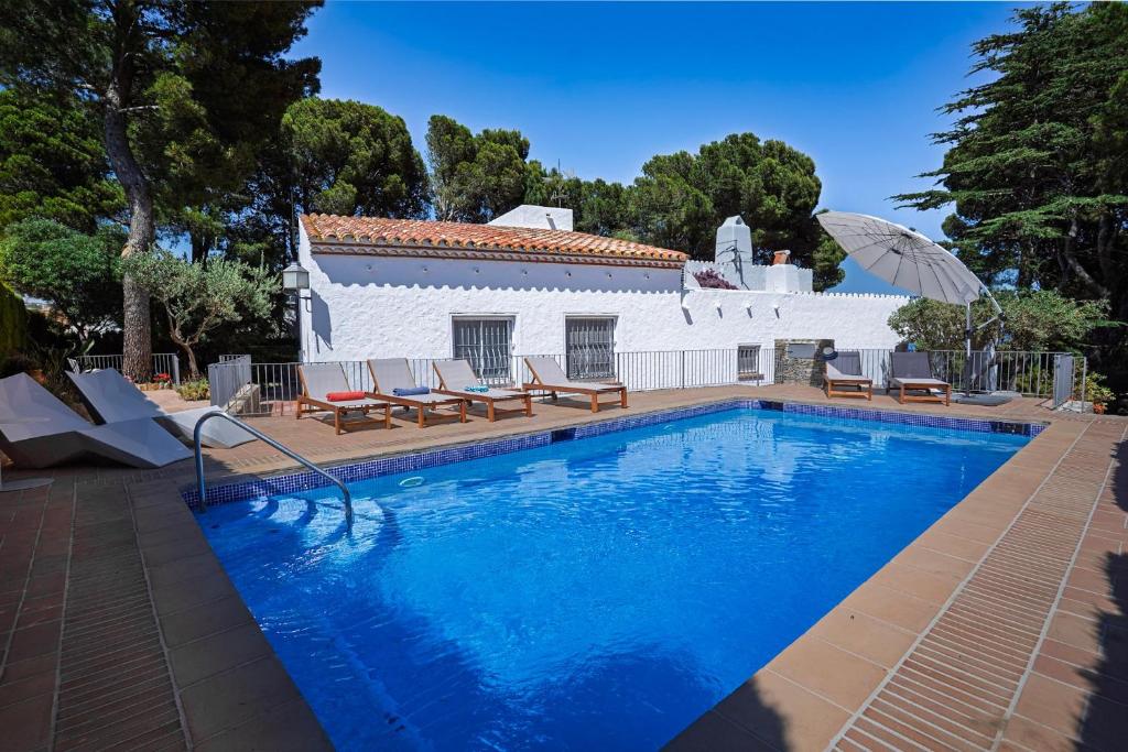 a swimming pool in front of a white house at Torre Sant Genís in Llança