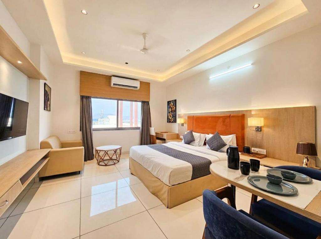 a large hotel room with a bed and a table at Soho Suites in Bedla