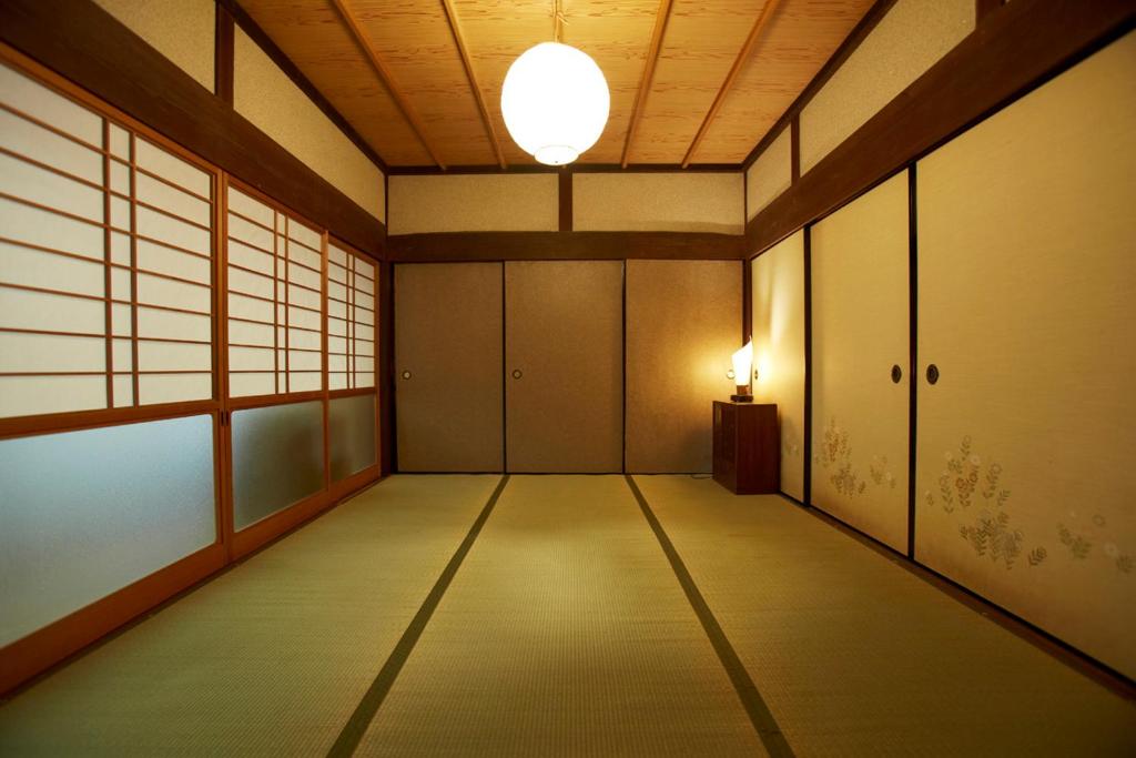 an empty room with a light on the ceiling at ゲストハウス やまんなか in Kamida