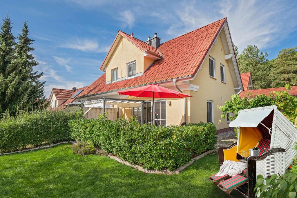 a house with a yard with a red roof at Heimathafen An Seen & Meer in Korswandt