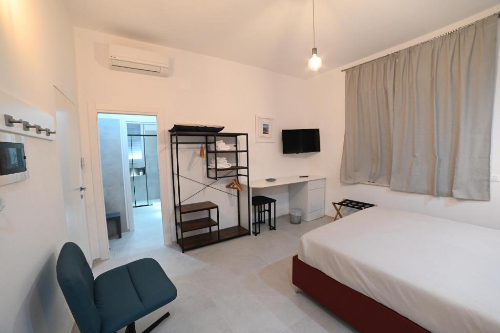 a bedroom with a bed and a desk with a computer at Brindisi Airport Rooms in Brindisi