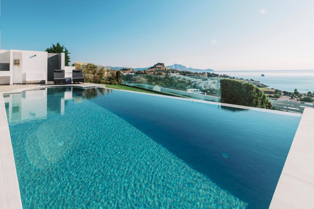 a large swimming pool with a view of the ocean at Cavo Lindos Villas in Lindos