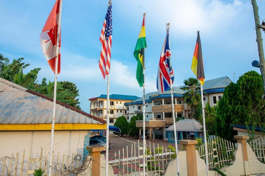 a group of flags in front of a building at GLAMOSSAY HOTEL LIMITED SUNYANi in Abesem