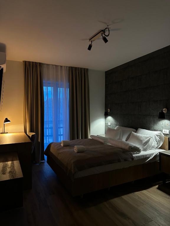 a bedroom with a large bed with a large window at Galerija Odzaci in Odžaci