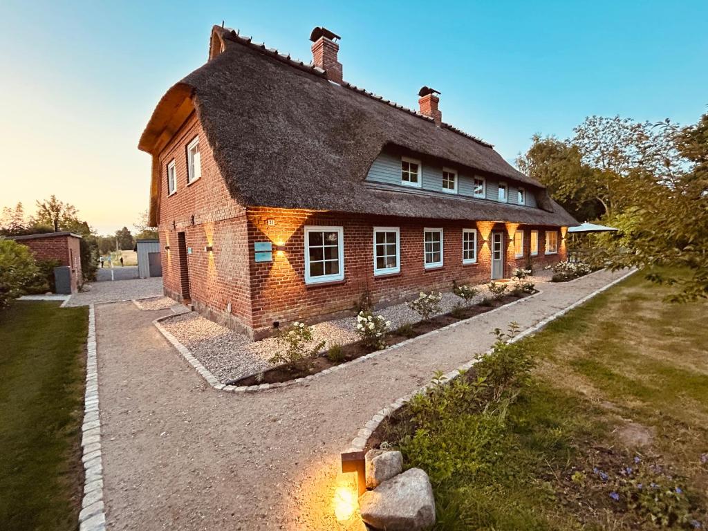 a large brick house with a pathway in front of it at Ferienwohnung Backbord Steinbergkirche in Steinbergkirche