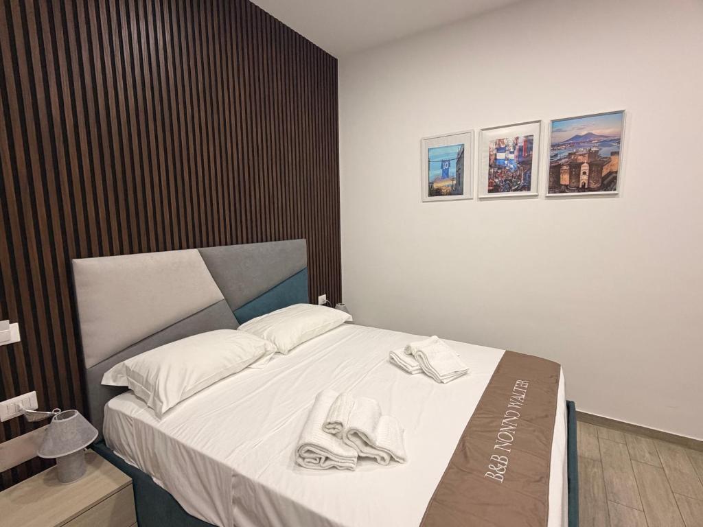 a bedroom with a bed with two pairs of shoes on it at B&B Nonno Walter in Torre del Greco