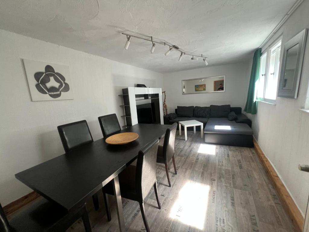 a dining room and living room with a black table and chairs at Schönste Aussicht in Königstein an der Elbe